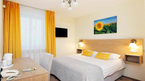 里加Hestia Hotel Draugi的酒店客房配有一张床铺和一张桌子。