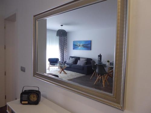 拉拉古纳NORASUITES32的客厅里一张金色镜子,配有沙发