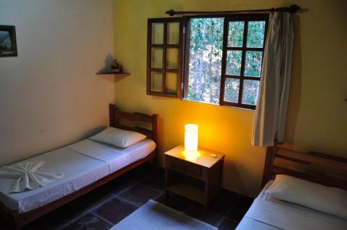 韦尔卡鲍卡斯特拉阿尔沃拉达旅馆的一间卧室设有两张床,一张桌子上放着蜡烛