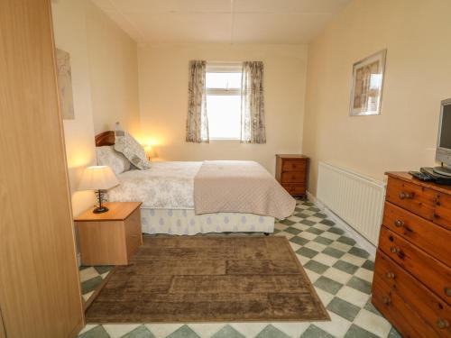 BallyboeGapple Cottage的一间卧室配有一张床、一个梳妆台和一扇窗户。