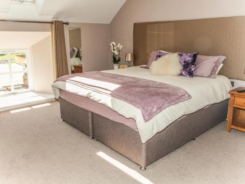 杜伦The Granary的一间卧室配有一张带紫色枕头的大床