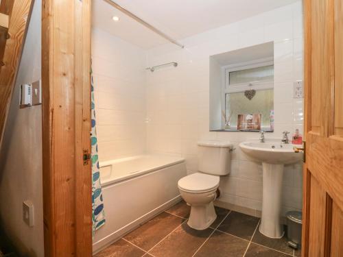 唐尼Creag Mhor Cottage的浴室配有卫生间、盥洗盆和浴缸。