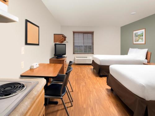威克斯巴勒WoodSpring Suites Wilkes-Barre的酒店客房设有两张床、一张书桌和一个厨房。