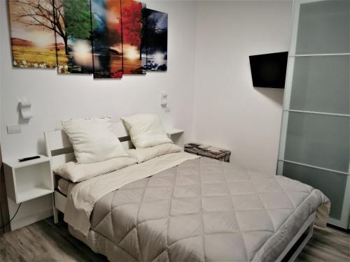 洛雷托Casa MaMiDa的卧室配有一张床,墙上挂有绘画作品