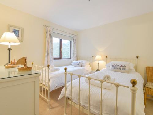 金斯布里奇12 Burgh Island Causeway的卧室配有白色的床和窗户。