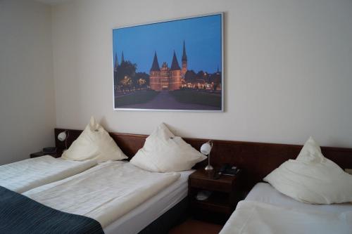 大格勒瑙圣胡贝图斯夫斯特翰斯酒店的两张位于酒店客房的床,墙上挂着照片
