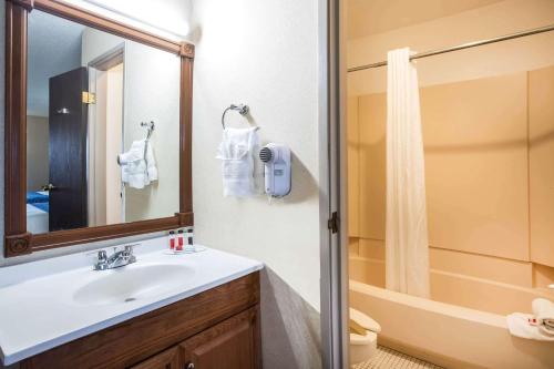 科罗拉多斯普林斯Travelodge by Wyndham Colorado Springs Airport/Peterson AFB的一间带水槽和淋浴的浴室