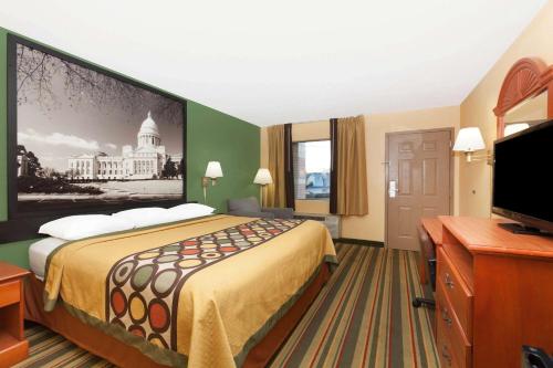 杰克逊维尔杰克逊维尔速8汽车旅馆的一间酒店客房,配有一张大床和一台平面电视