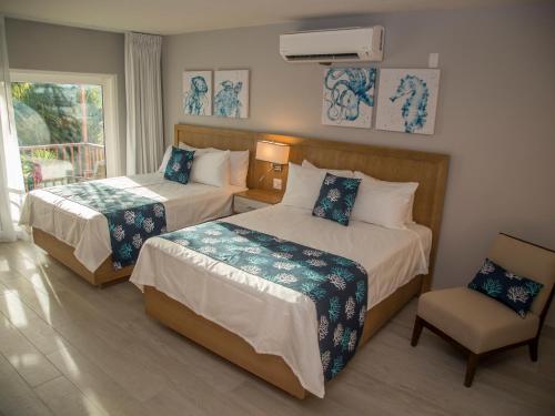 圣约翰斯西波涅海滩俱乐部的酒店客房,配有两张床和椅子