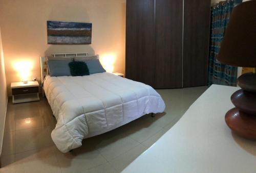KirkopThe Village Apartment 2的卧室配有一张白色大床和两盏灯。