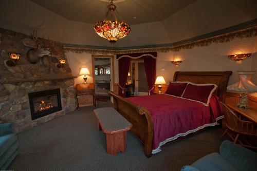 莱文沃思Beaver Valley Lodge的一间卧室设有一张大床和一个壁炉