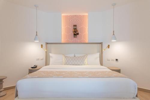 蓬塔卡纳Grand Bavaro Princess - All Inclusive的一间卧室配有一张大白色床和两个吊灯