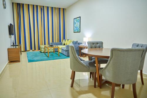 迪拜City Stay Grand Hotel Apartments - Al Barsha的客厅配有桌椅和沙发