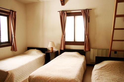 白马村格雷伯爵酒店的一间卧室设有两张床和窗户。