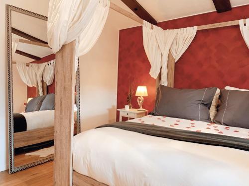 Prez-vers-SiviriezLa Maisonnette Enchantée的一间卧室配有天蓬床和镜子