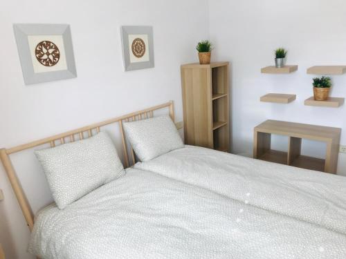 El MoncayoCasa Pura Vida Guardamar del Segura的一间卧室配有一张带白色床单和一张桌子的床。