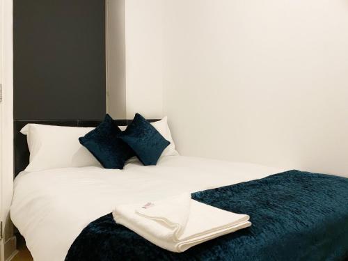 格拉斯哥Cozy Nights - Ibrox Street的一间卧室配有白色床和蓝色枕头