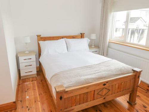 BallymoteDuffy's Cottage的一间卧室配有一张木框床和窗户。