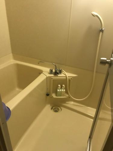 大阪Osaka Ryokan Kuramoto的浴缸内装有水管,连接起来