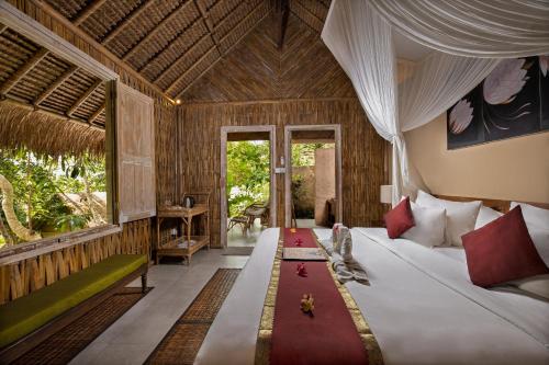 珀尼达岛The Mesare Eco Resort的一间卧室设有一张床和一个大窗户