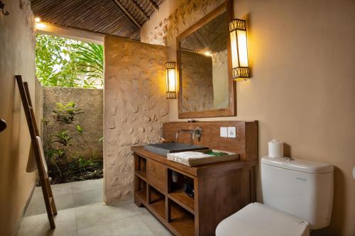 珀尼达岛The Mesare Eco Resort的浴室设有卫生间和带镜子的盥洗盆
