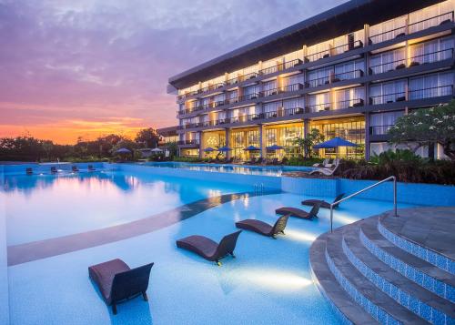 TanjungbingaSwiss-Belresort Belitung的酒店设有一个大型游泳池,配有椅子