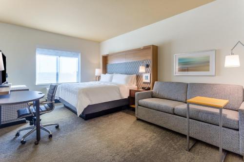 锡达福尔斯Holiday Inn & Suites Cedar Falls-Waterloo Event Ctr, an IHG Hotel的酒店客房,配有床和沙发