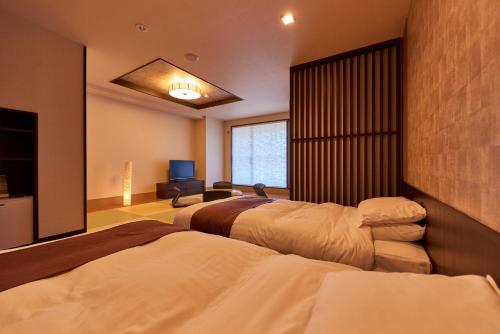 二世古西拉福特尼斯科王子酒店的一间卧室配有两张床和电视。