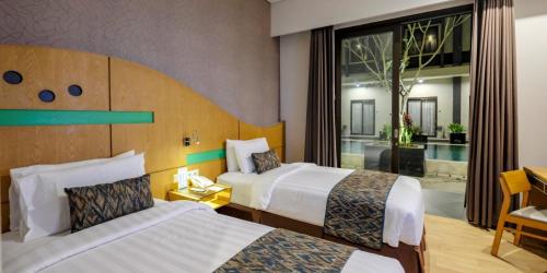 普拉亚ILLIRA Lite Praya Lombok的酒店客房设有两张床和大窗户。