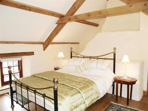 GoodwickPanteurig Cottage的一间卧室设有一张大床和木制天花板。