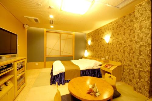 Katsuragiホテル チャペル クリスマス かつらぎ Adult Only的客房设有1张床、1张桌子和1台电视。