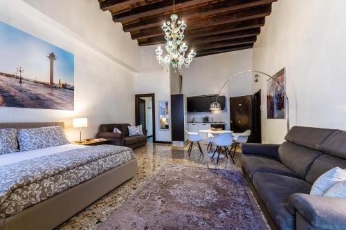 威尼斯查圣天使酒店的一间卧室配有一张床、一张沙发和一张桌子
