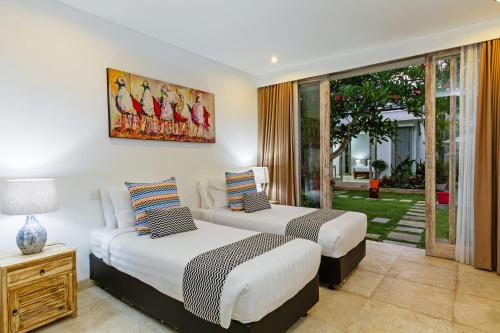 沙努尔Villa Frangi的配有窗户的酒店客房内的两张床