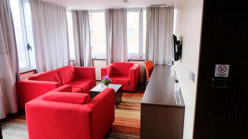 泽尼察Hotel Richi的客厅配有红色椅子和电视