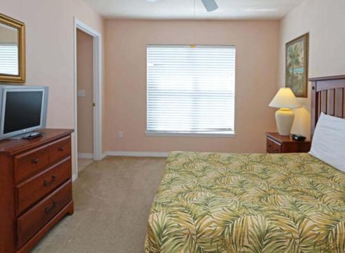 达文波特Villa Alexa的一间卧室配有一张床和一台平面电视
