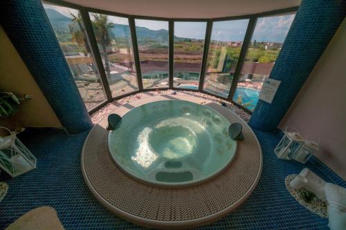 格里索利亚Valtur Il Cormorano Resort & Spa的一个带大窗户的客房内的按摩浴缸