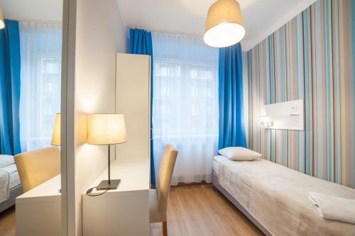 克拉科夫普瑞米安旅馆的一间卧室配有一张床和一张带台灯的书桌