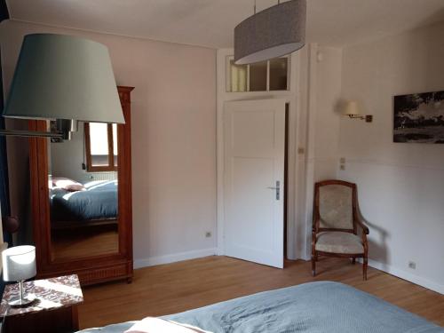 ScherwillerChambre double dans Auberge Alsacienne的一间卧室配有镜子、一张床和一把椅子