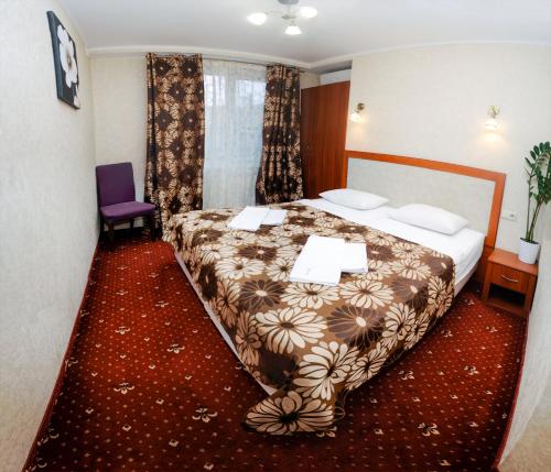 伊万诺-弗兰科夫斯克豪华公寓式酒店的酒店客房,配有一张床和一张紫色椅子