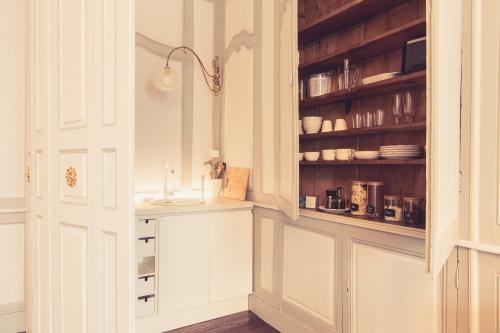 普瓦捷La Maison de la Liberté Suite Jeanne Barret的厨房配有白色橱柜和水槽
