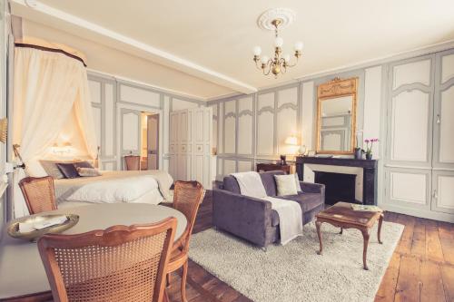 普瓦捷La Maison de la Liberté Suite Jeanne Barret的一间卧室配有一张床、一张沙发和一个壁炉