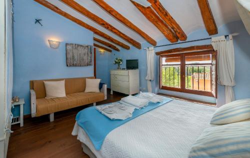 VilardidaLes Vinyes Alojamiento Rural Boutique & SPA的一间卧室配有一张床、一张沙发和一个窗口
