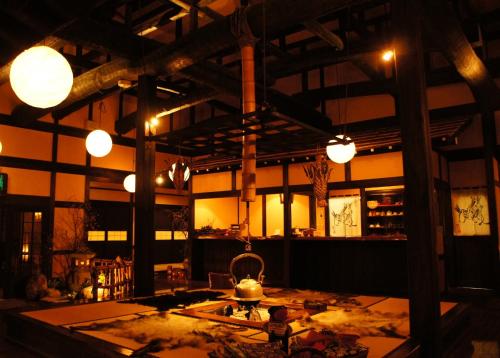 高山飞騨路传统日式旅馆（仅限成人入住）的大楼内带桌子和灯的房间