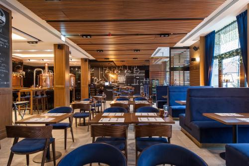 比亚韦斯托克皇家酒店及Spa的餐厅设有木制天花板和桌椅