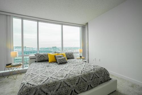 巴尔的摩Heaven On Baltimore Downtown Fully Furnished Apartments的一间卧室设有一张大床和大窗户