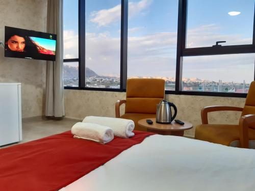 杰里科Dolphin Suites Hotel的一间卧室配有一张大床和一台平面电视