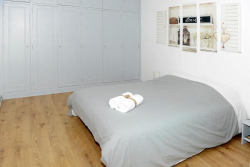 格朗维尔La corderie du Lude的白色卧室,配有带毛巾的床