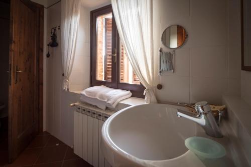 卡斯特利纳-因基安蒂Collelungo的白色的浴室设有水槽和窗户。