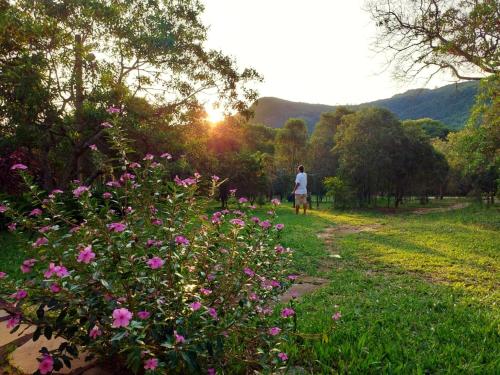 圣托梅-达斯莱特拉斯Camping do Delei的走在一条有粉红色花朵的小径上的人