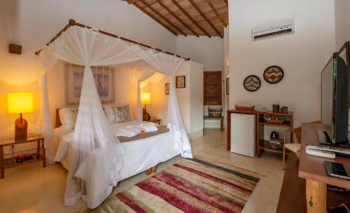 托兰克索Hotel e Resort Villas de Trancoso的一间卧室配有一张带蚊帐的床